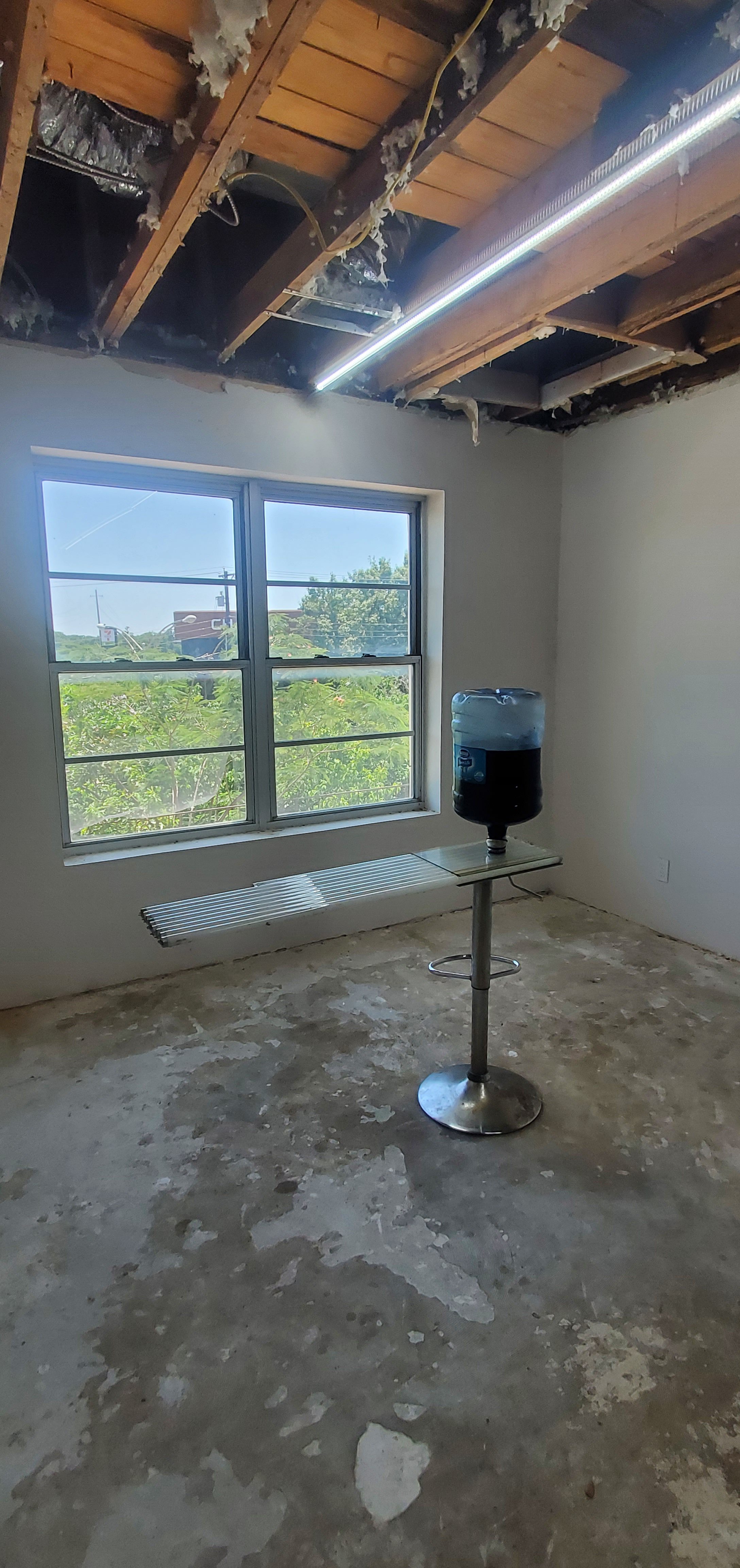 Water jug with dark liquid balances on glass tubes and stool.